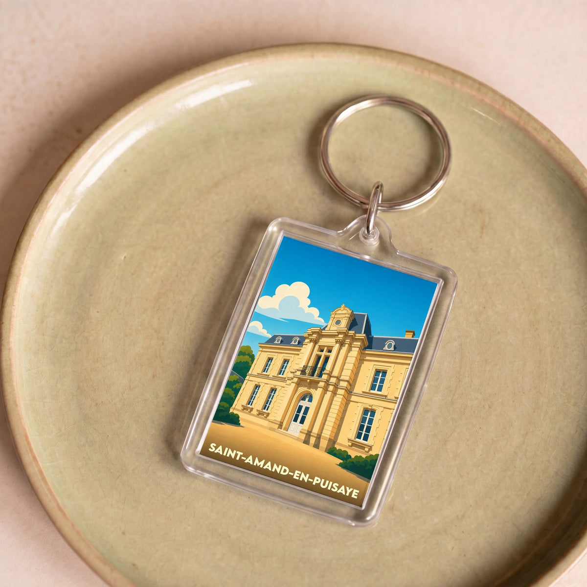 Porte-clés souvenir de la ville de Saint-Amand-en-Puisaye avec une illustration stylisée du château local.