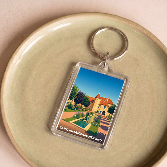 Porte-clés souvenir de la ville de Saint-Amand-Montrond avec une illustration stylisée d'un château et de ses jardins.