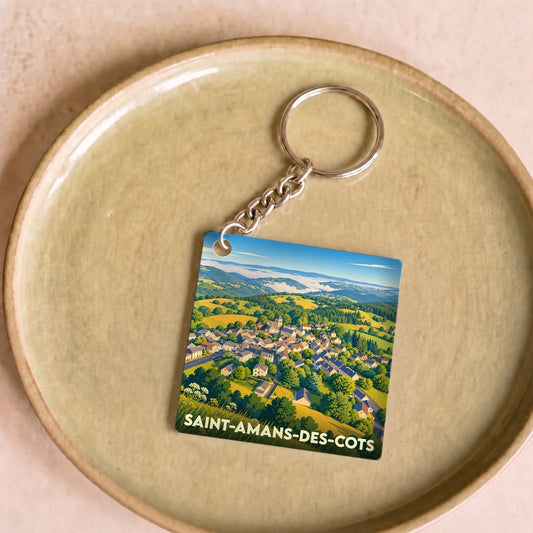 Porte-clés souvenir de la commune de Saint-Amans-des-Cots avec une illustration panoramique stylisée du village.