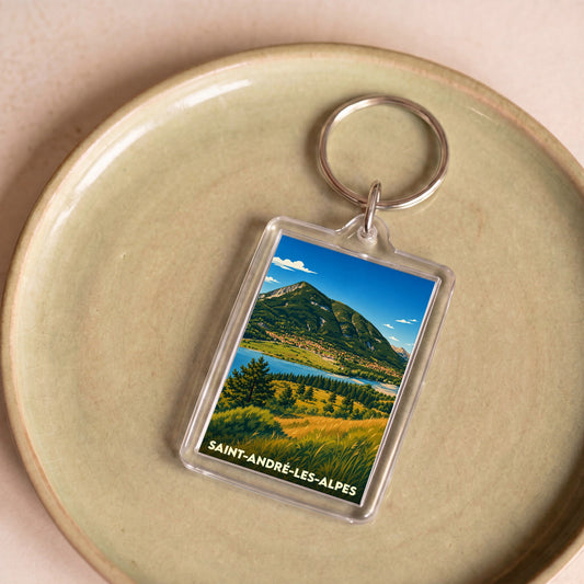 Porte-clés souvenir de la ville de Saint-André-les-Alpes avec une illustration stylisée de montagne et de lac.