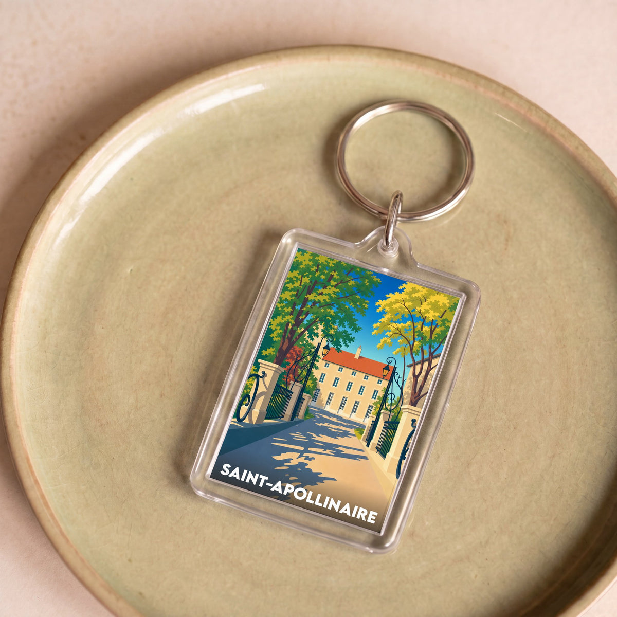 Porte-clés souvenir de la ville de Saint-Apollinaire avec une illustration stylisée d'un bâtiment historique.
