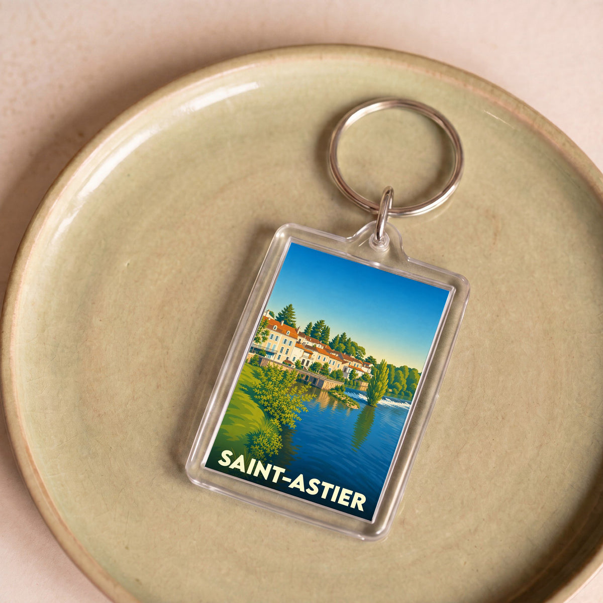 Porte-clés souvenir de la ville de Saint-Astier avec une illustration stylisée.