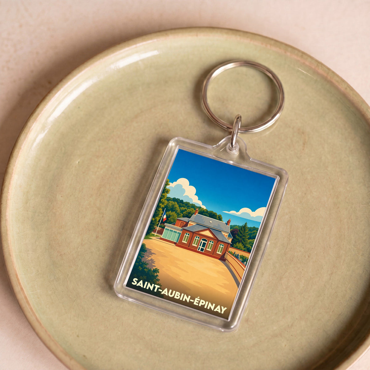 Porte-clés souvenir de la ville de Saint-Aubin-Épinay avec une illustration stylisée.