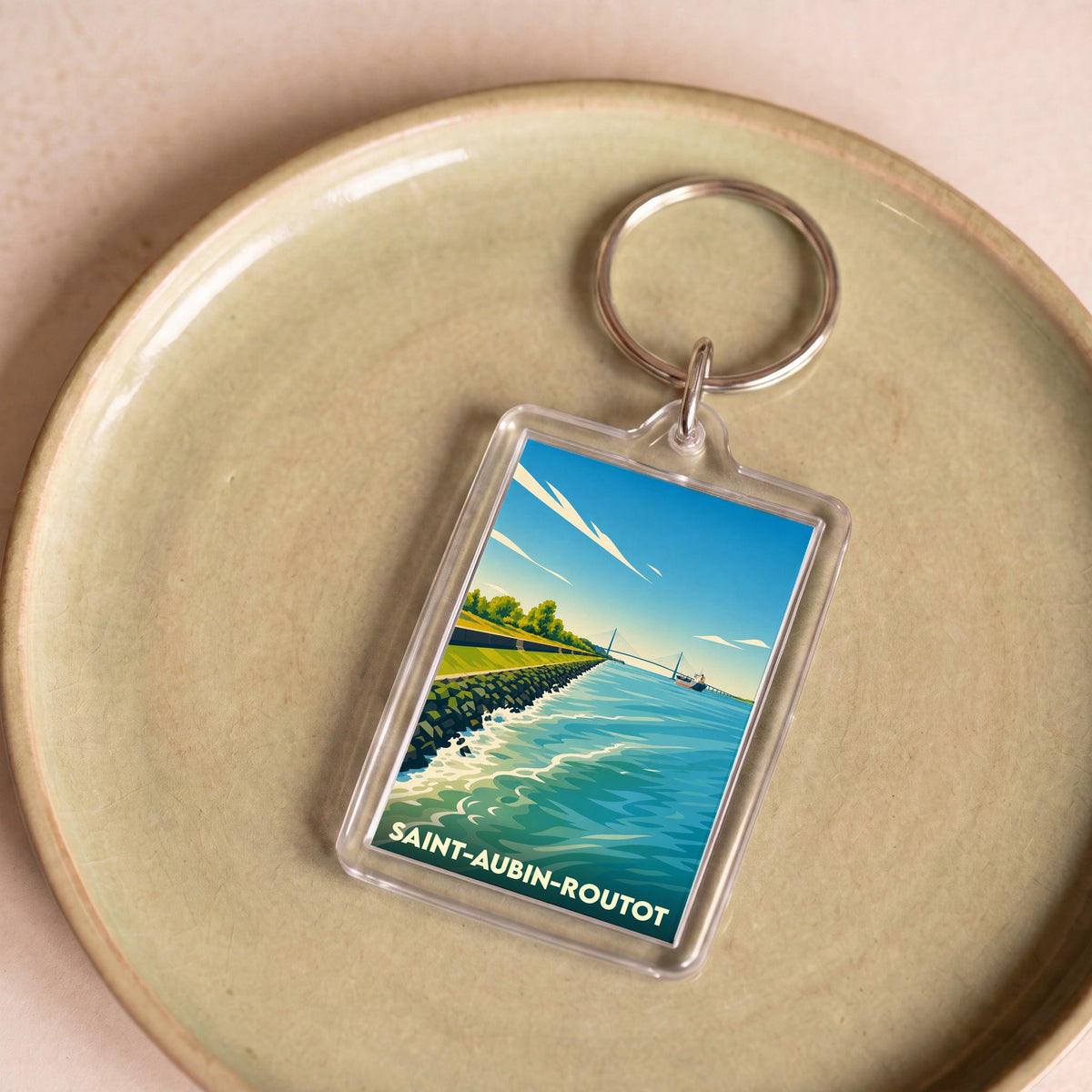Porte-clés souvenir de Saint-Aubin-Routot avec une illustration stylisée d'un paysage côtier.