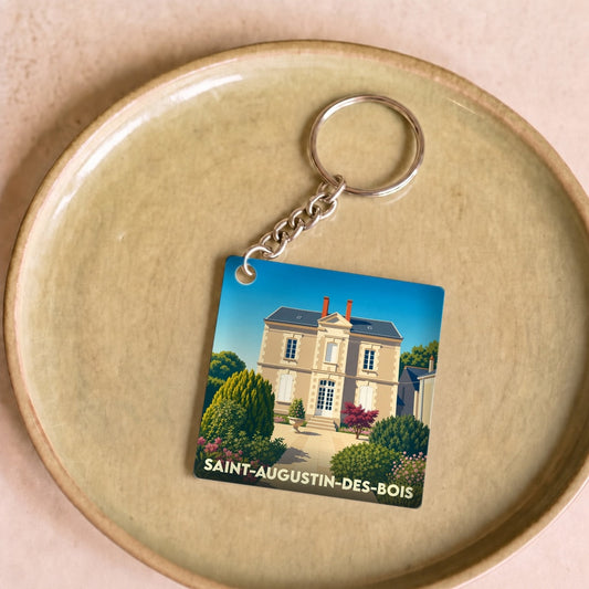 Porte-clés souvenir de la ville de Saint-Augustin-des-Bois avec une illustration stylisée d'une demeure bourgeoise.