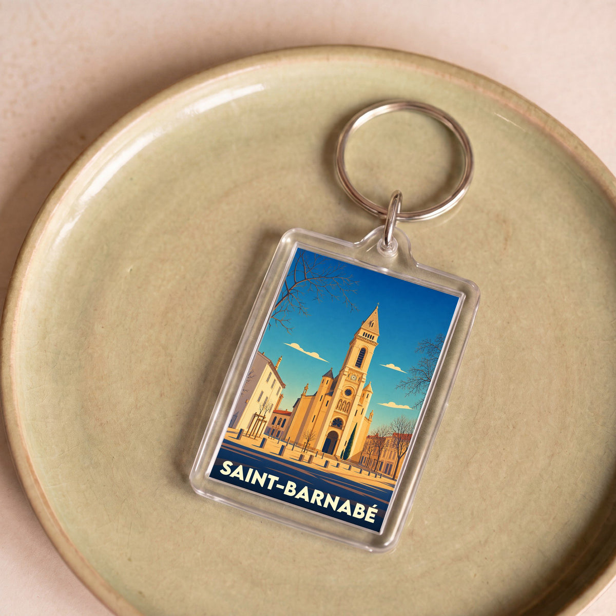 Porte-clés souvenir de la ville de Saint-Barnabé avec une illustration stylisée de son église.