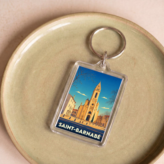 Porte-clés souvenir de la ville de Saint-Barnabé avec une illustration stylisée de son église.