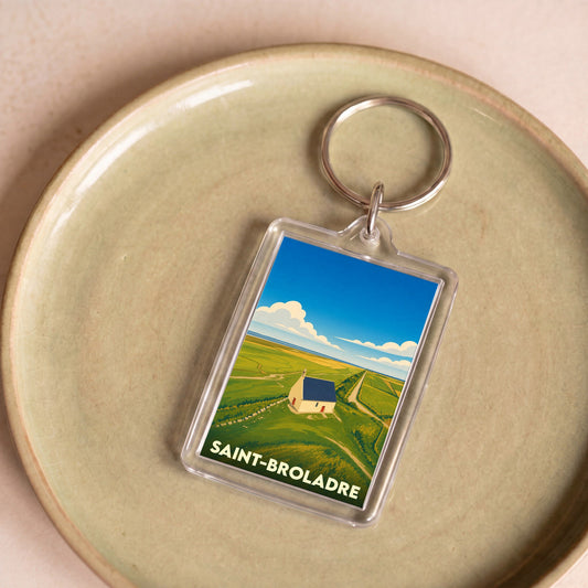 Porte-clés souvenir de la ville de Saint-Broladre avec une illustration stylisée de sa chapelle dans les polders.