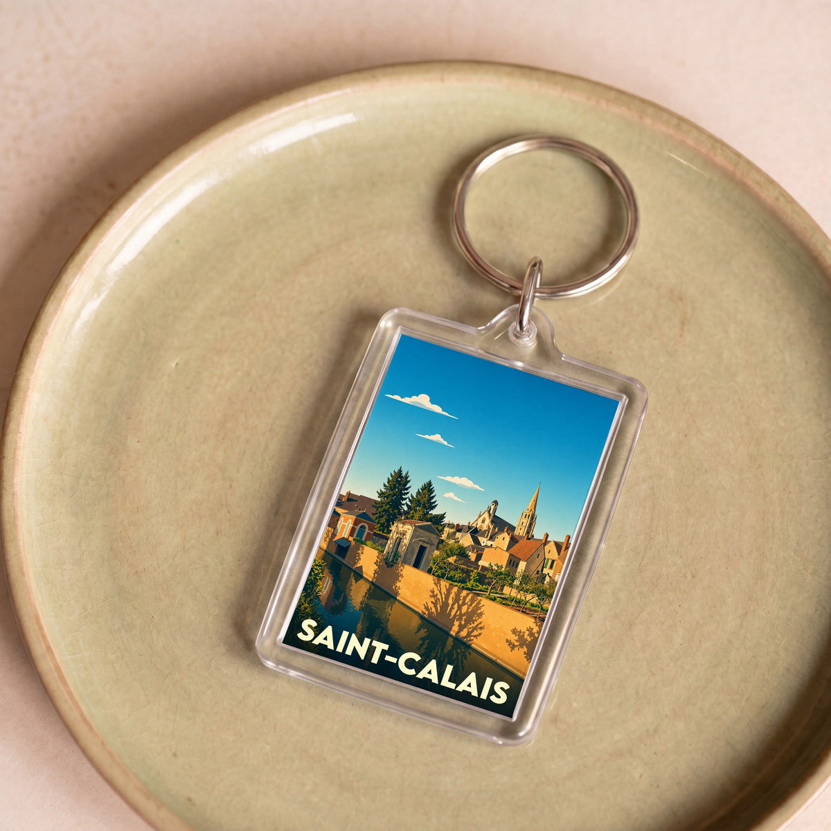 Porte-clés souvenir de la ville de Saint-Calais avec une illustration stylisée.