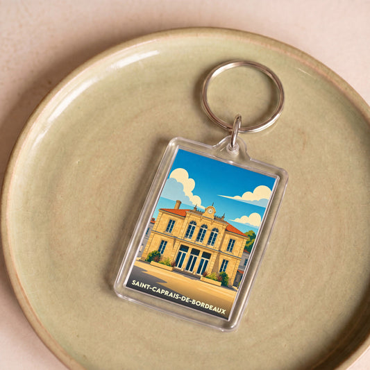 Porte-clés souvenir de la ville de Saint-Caprais-de-Bordeaux avec une illustration stylisée.