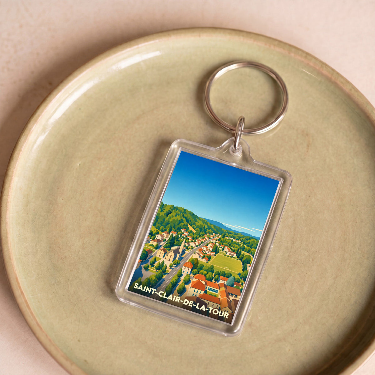 Porte-clés souvenir de la ville de Saint-Clair-de-la-Tour avec une illustration stylisée.