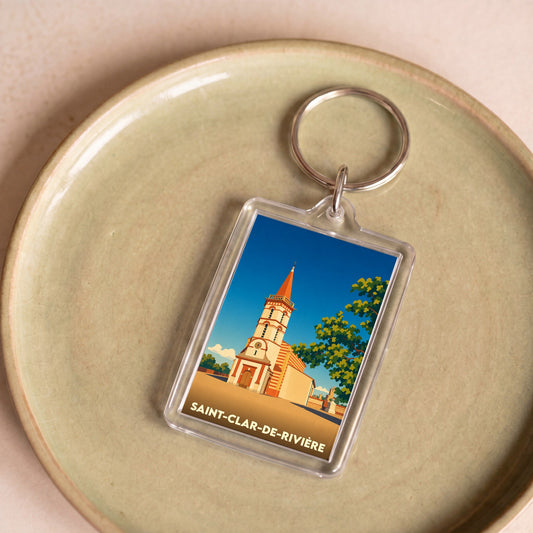 Porte-clés souvenir de la ville de Saint-Clar-de-Rivière avec une illustration stylisée de son église.