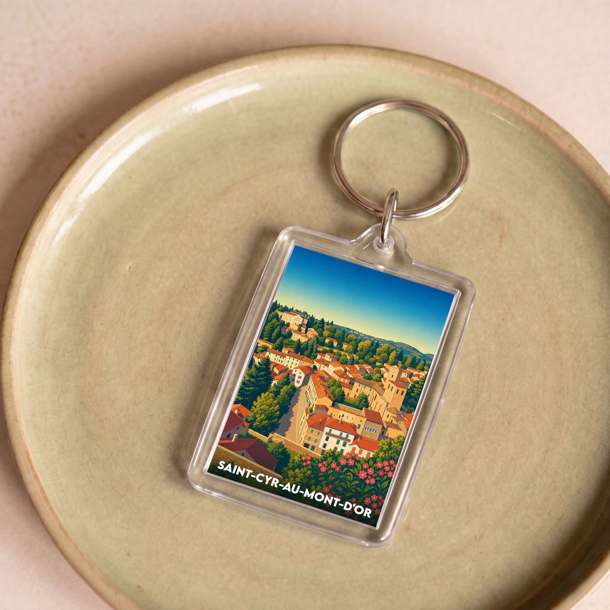 Porte-clés souvenir de la ville de Saint-Cyr-au-Mont-d'Or avec une illustration stylisée et colorée du village.