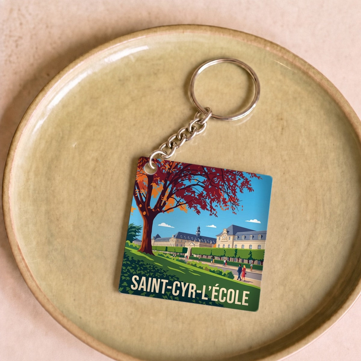 Porte-clés souvenir de la ville de Saint-Cyr-l'École avec une illustration stylisée.