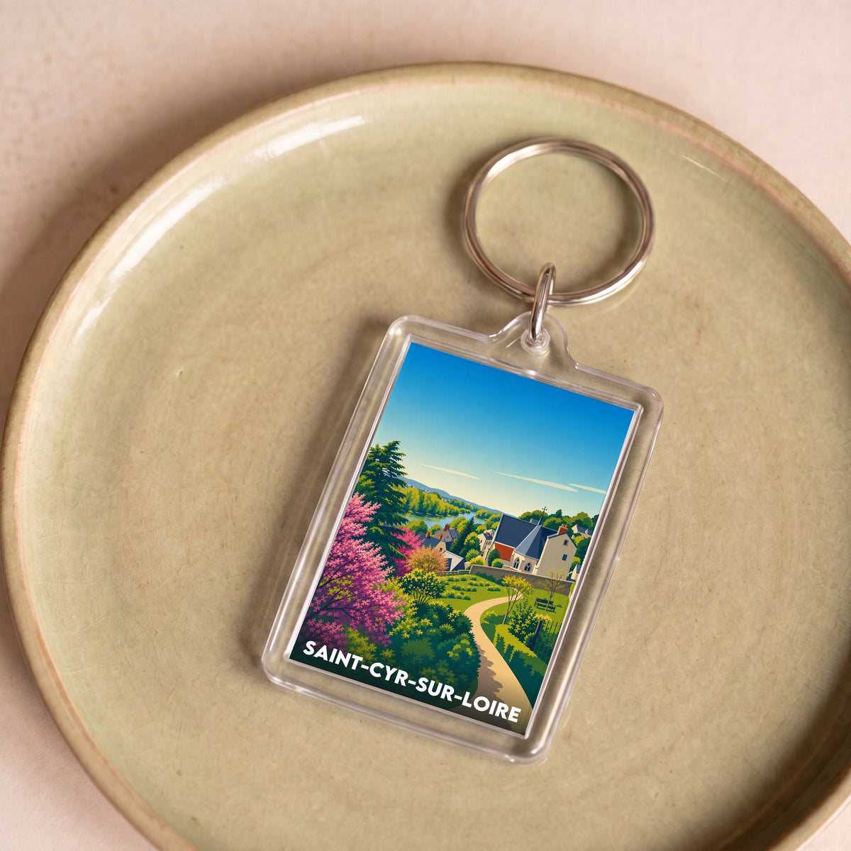 Porte-clés souvenir de la ville de Saint-Cyr-sur-Loire avec une illustration stylisée.