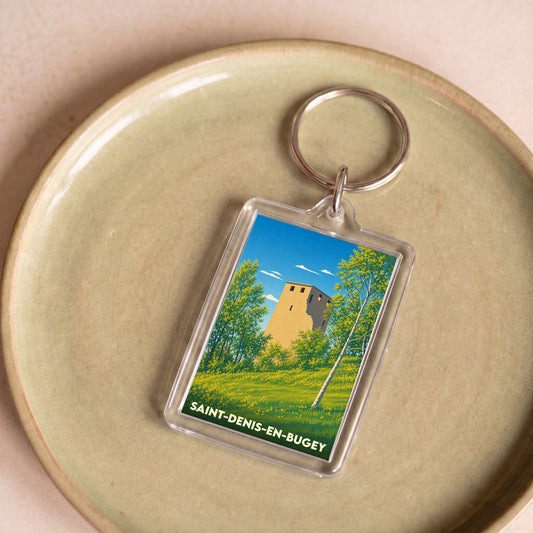 Porte-clés souvenir de la ville de Saint-Denis-en-Bugey illustrant une tour médiévale entourée de verdure.