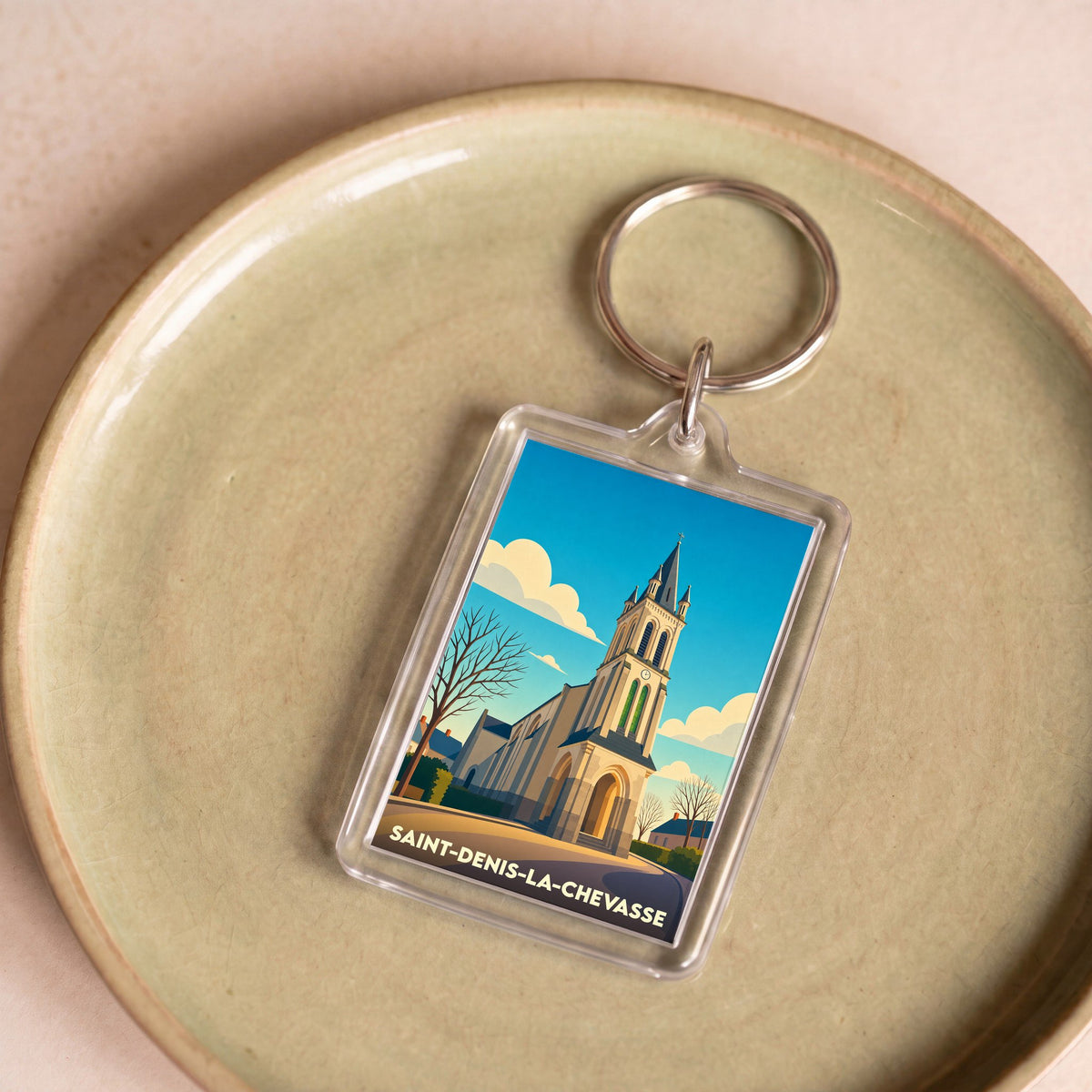 Porte-clés souvenir de la ville de Saint-Denis-la-Chevasse avec une illustration stylisée de son église.