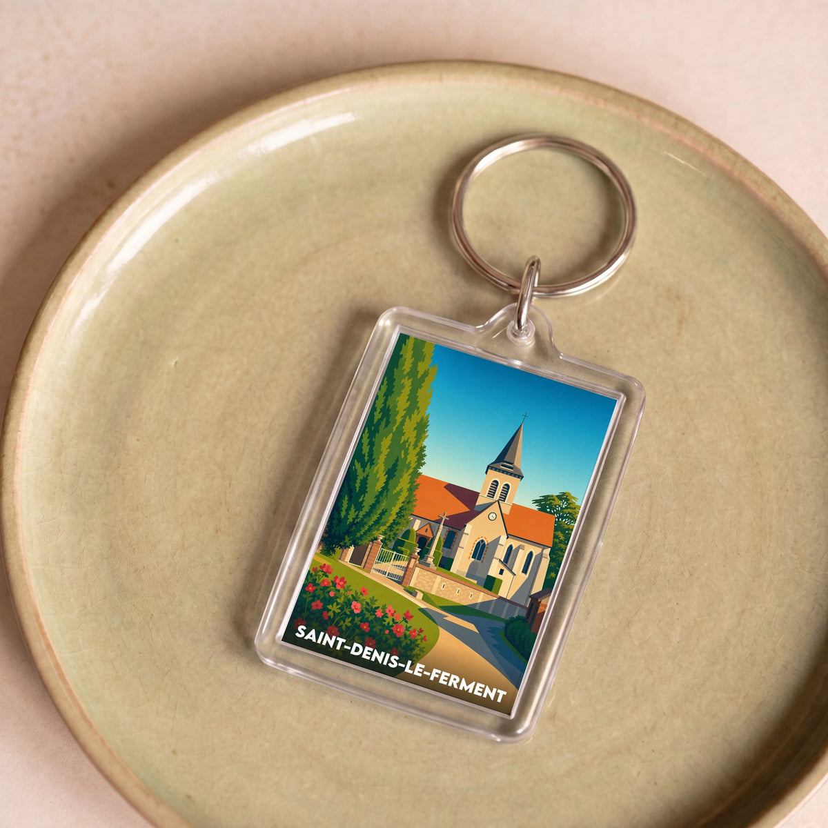 Porte-clés souvenir de la ville de Saint-Denis-le-Ferment avec une illustration stylisée.