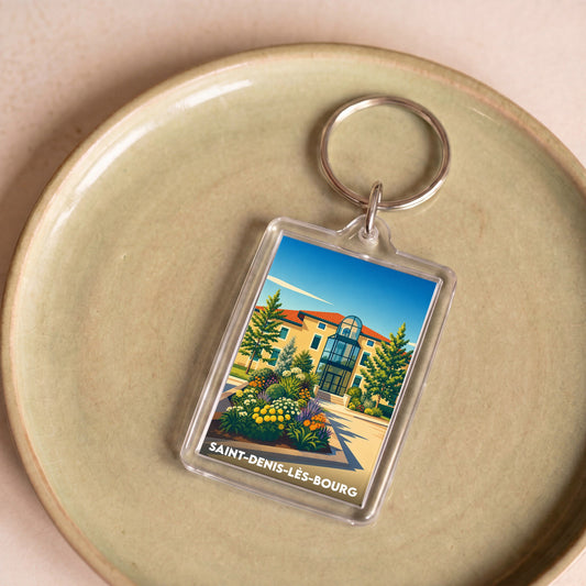 Porte-clés souvenir de la ville de Saint-Denis-lès-Bourg avec une illustration colorée et stylisée de sa mairie.
