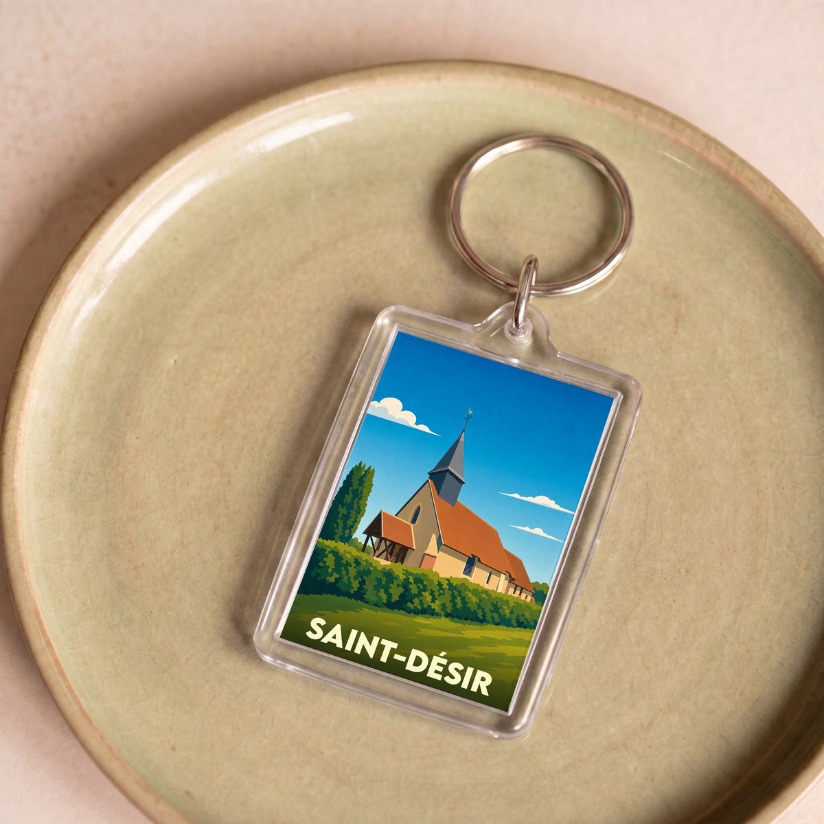 Porte-clés souvenir de la ville de Saint-Désir avec une illustration stylisée de son église.