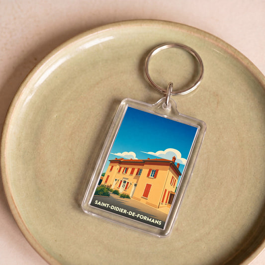 Porte-clés souvenir de la ville de Saint-Didier-de-Formans avec une illustration stylisée.