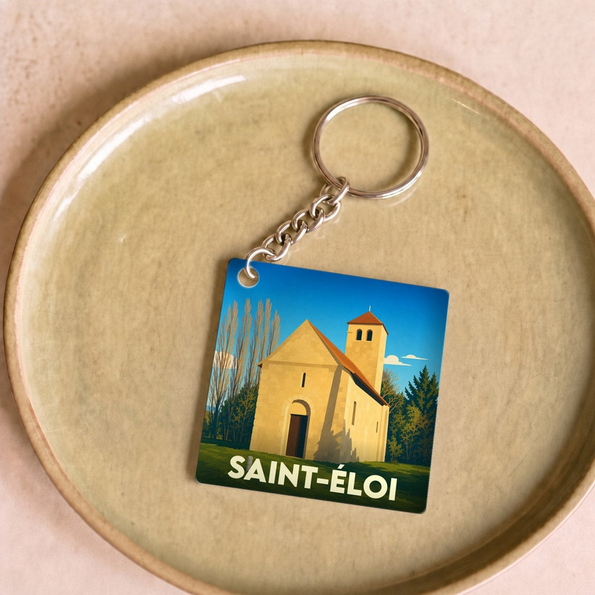 Porte-clés souvenir de la ville de Saint-Éloi avec une illustration stylisée.