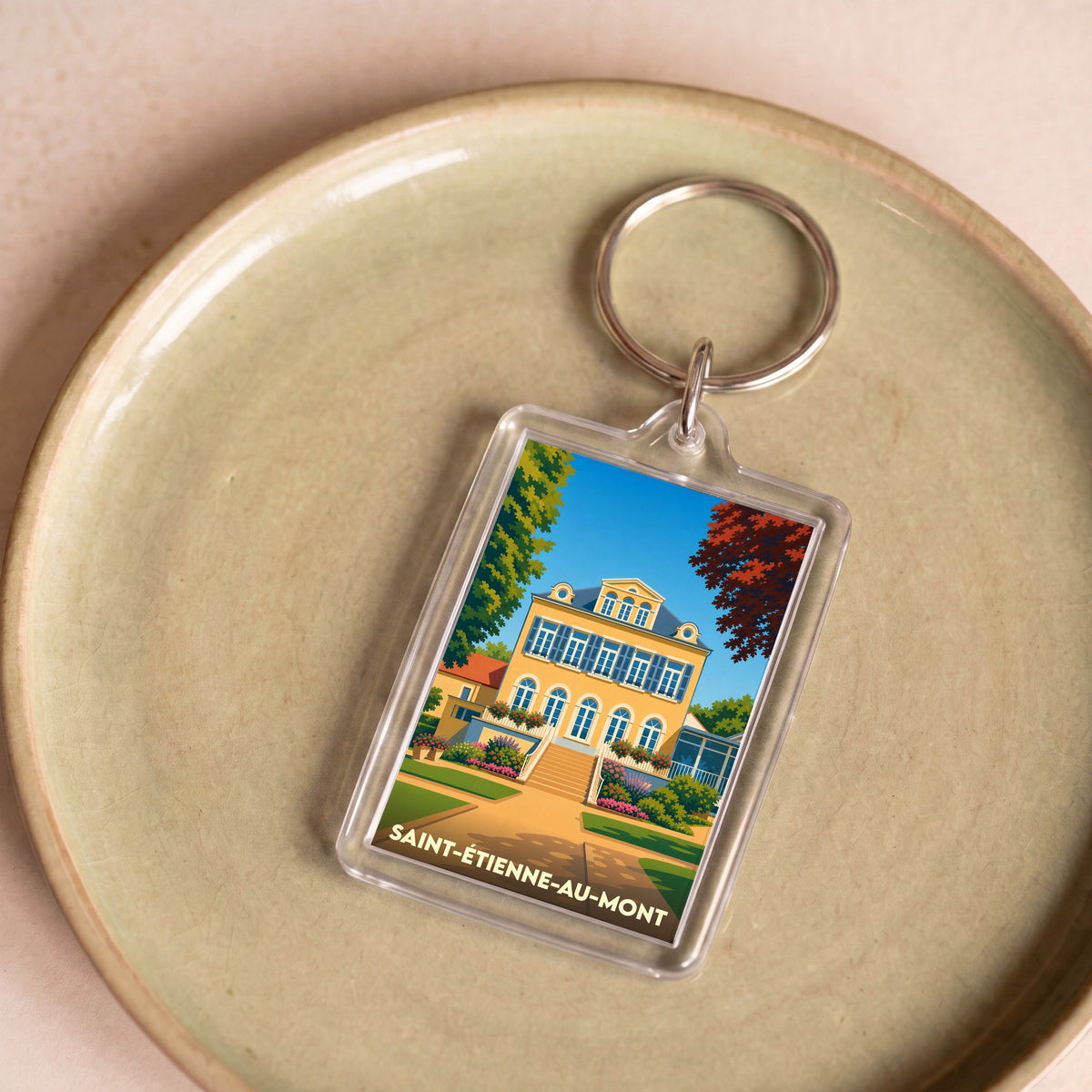 Porte-clés souvenir de la ville de Saint-Étienne-au-Mont avec une illustration stylisée.