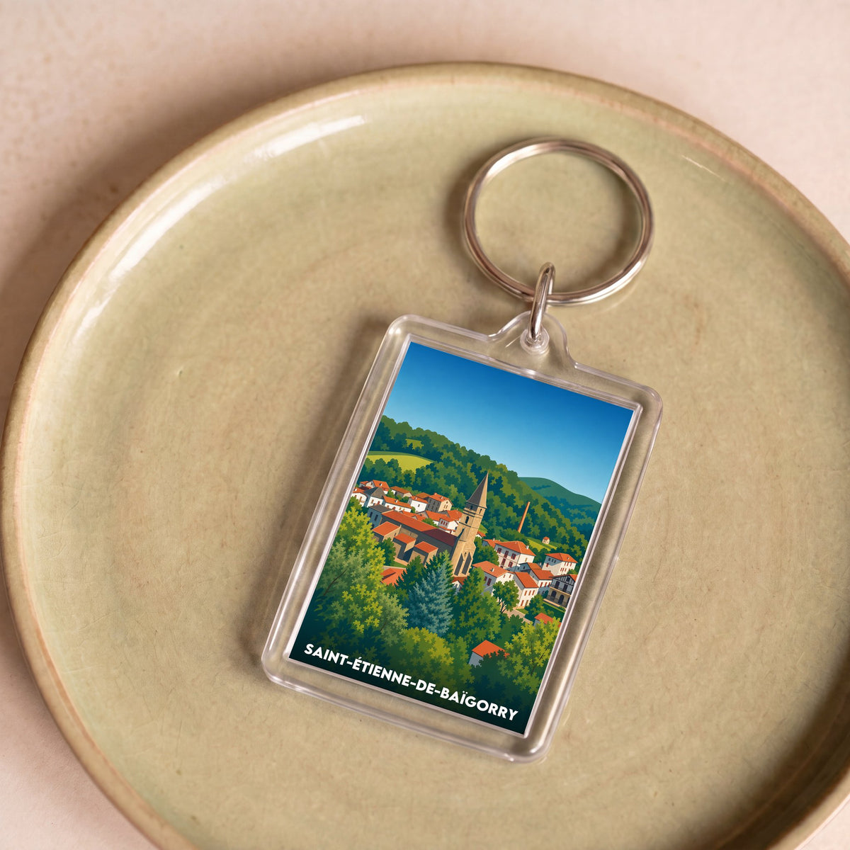 Porte-clés souvenir de la ville de Saint-Étienne-de-Baïgorry avec une illustration stylisée.