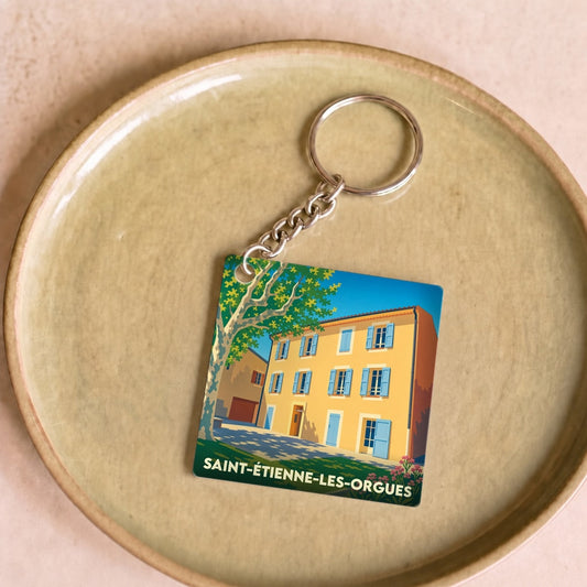 Porte-clés souvenir de la ville de Saint-Étienne-les-Orgues avec une illustration stylisée d'une maison provençale.
