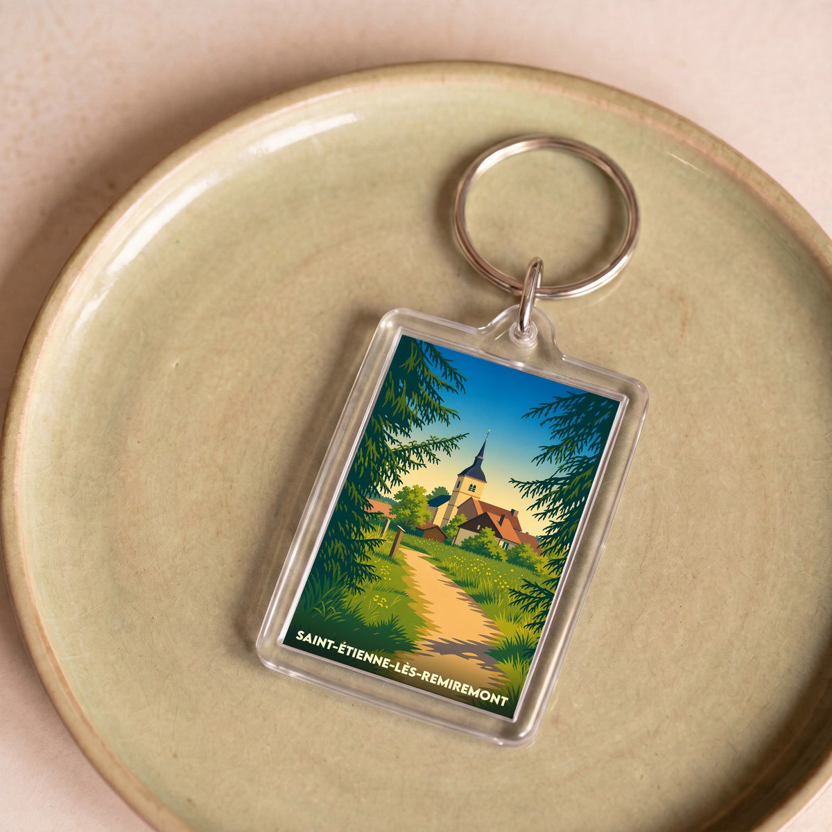 Porte-clés souvenir de la ville de Saint-Étienne-lès-Remiremont avec une illustration stylisée.