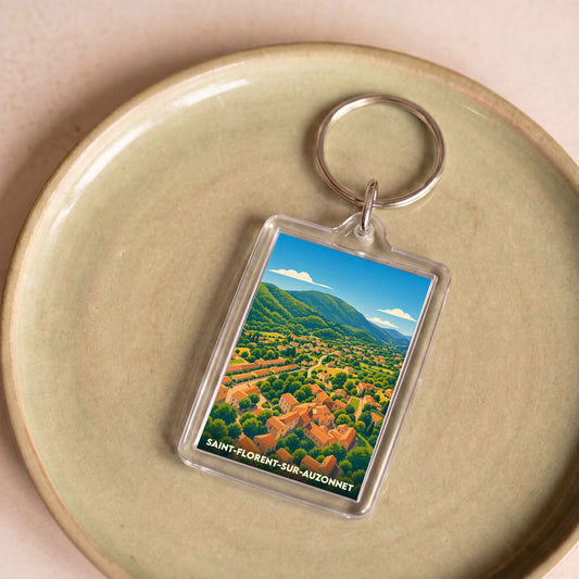 Porte-clés souvenir de la ville de Saint-Florent-sur-Auzonnet avec une illustration stylisée d'un paysage de village.