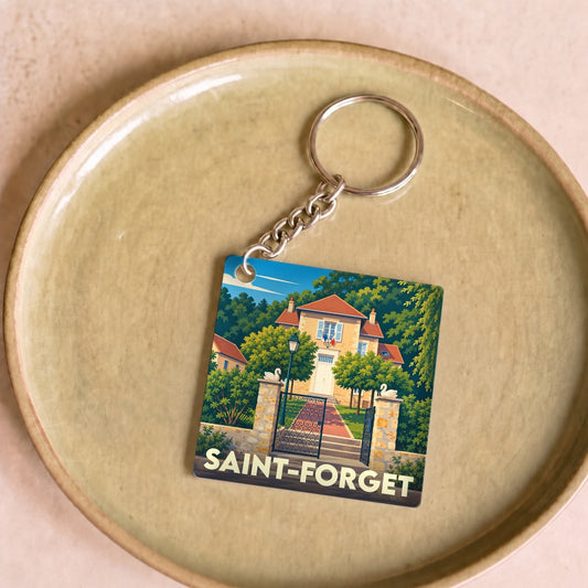 Porte-clés souvenir de la ville de Saint-Forget avec une illustration stylisée d'une maison bourgeoise.