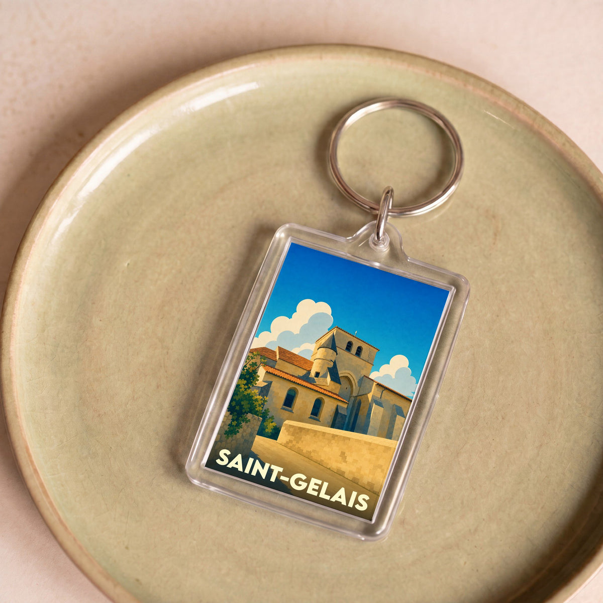 Porte-clés souvenir de la ville de Saint-Gelais avec une illustration stylisée de son église romane.