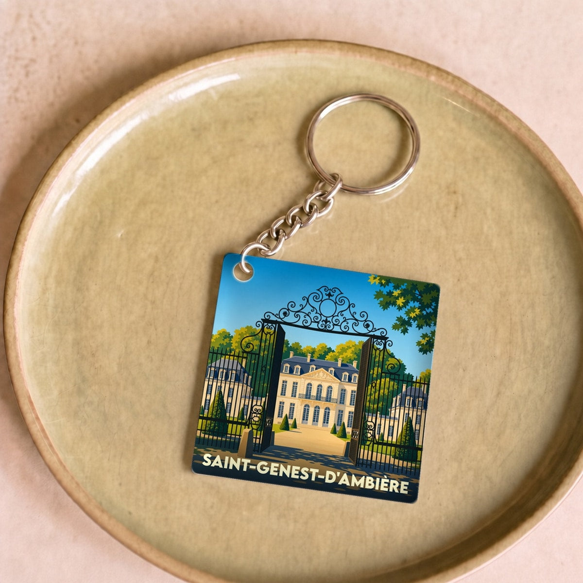 Porte-clés souvenir de la ville de Saint-Genest-d'Ambière avec une illustration stylisée.