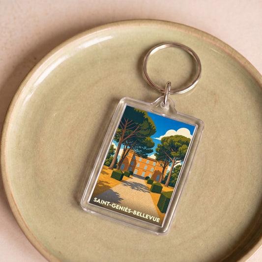 Porte-clés souvenir de la ville de Saint-Geniès-Bellevue avec une illustration stylisée d'un château.