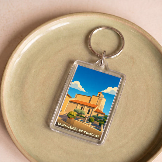 Porte-clés souvenir de la ville de Saint-Geniès-de-Comolas avec une illustration stylisée de son église.