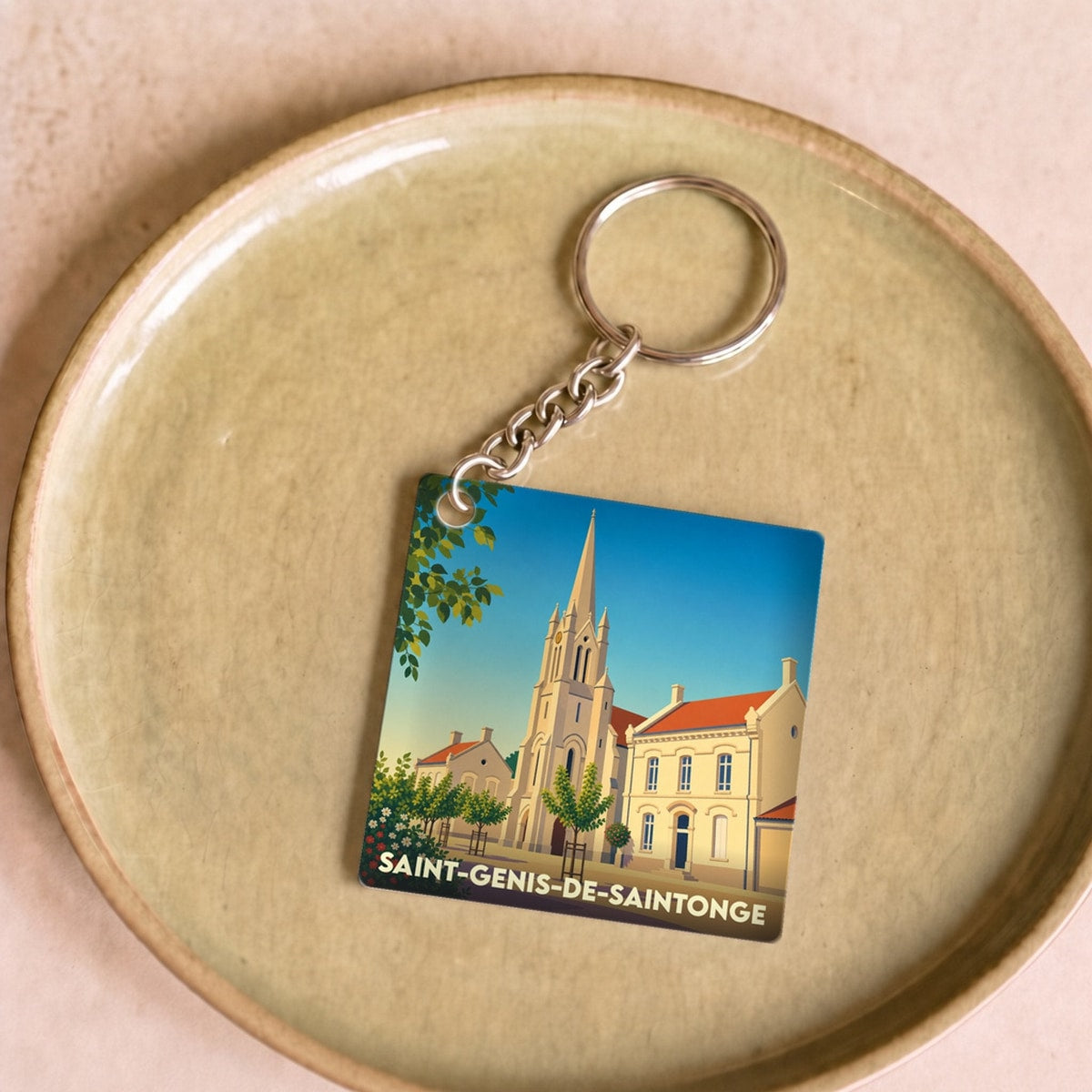 Porte-clés souvenir de la ville de Saint-Genis-de-Saintonge avec une illustration stylisée de son église.