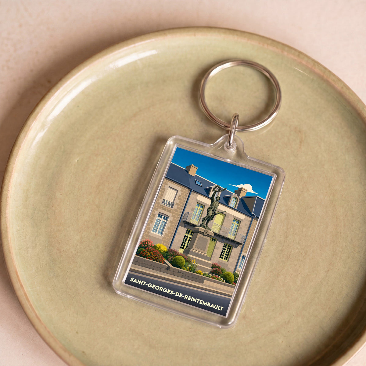 Porte-clés souvenir de la ville de Saint-Georges-de-Reintembault avec une illustration stylisée.