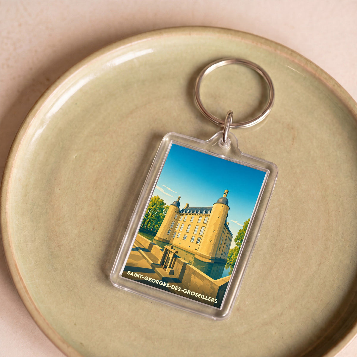 Porte-clés souvenir de la ville de Saint-Georges-des-Groseillers avec une illustration stylisée de son château.