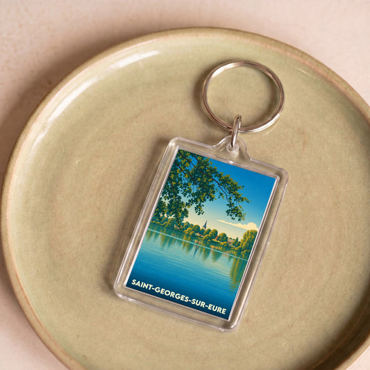 Porte-clés souvenir de la ville de Saint-Georges-sur-Eure avec une illustration stylisée d'un paysage de bord d'eau.