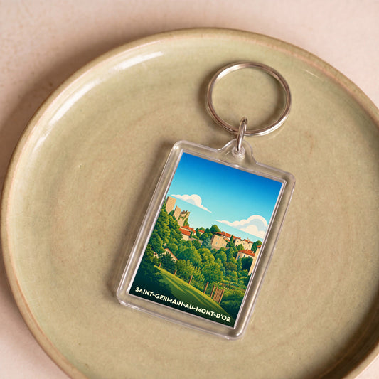 Porte-clés souvenir de Saint-Germain-au-Mont-d'Or avec une illustration stylisée du village et ses collines.