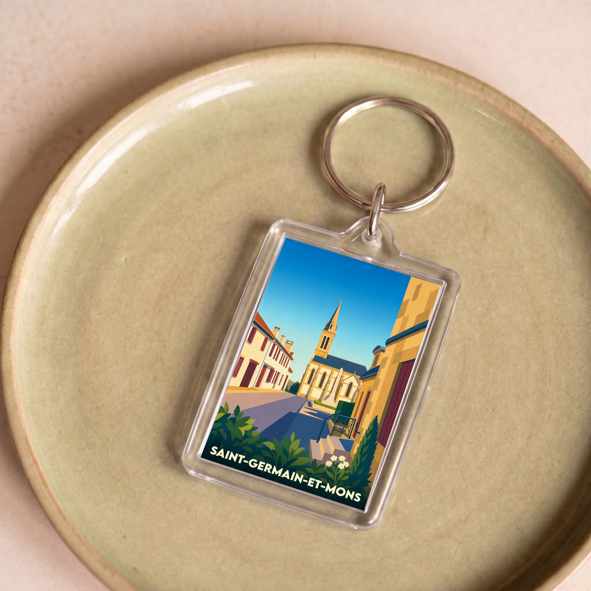 Porte-clés souvenir de la ville de Saint-Germain-et-Mons avec une illustration stylisée.