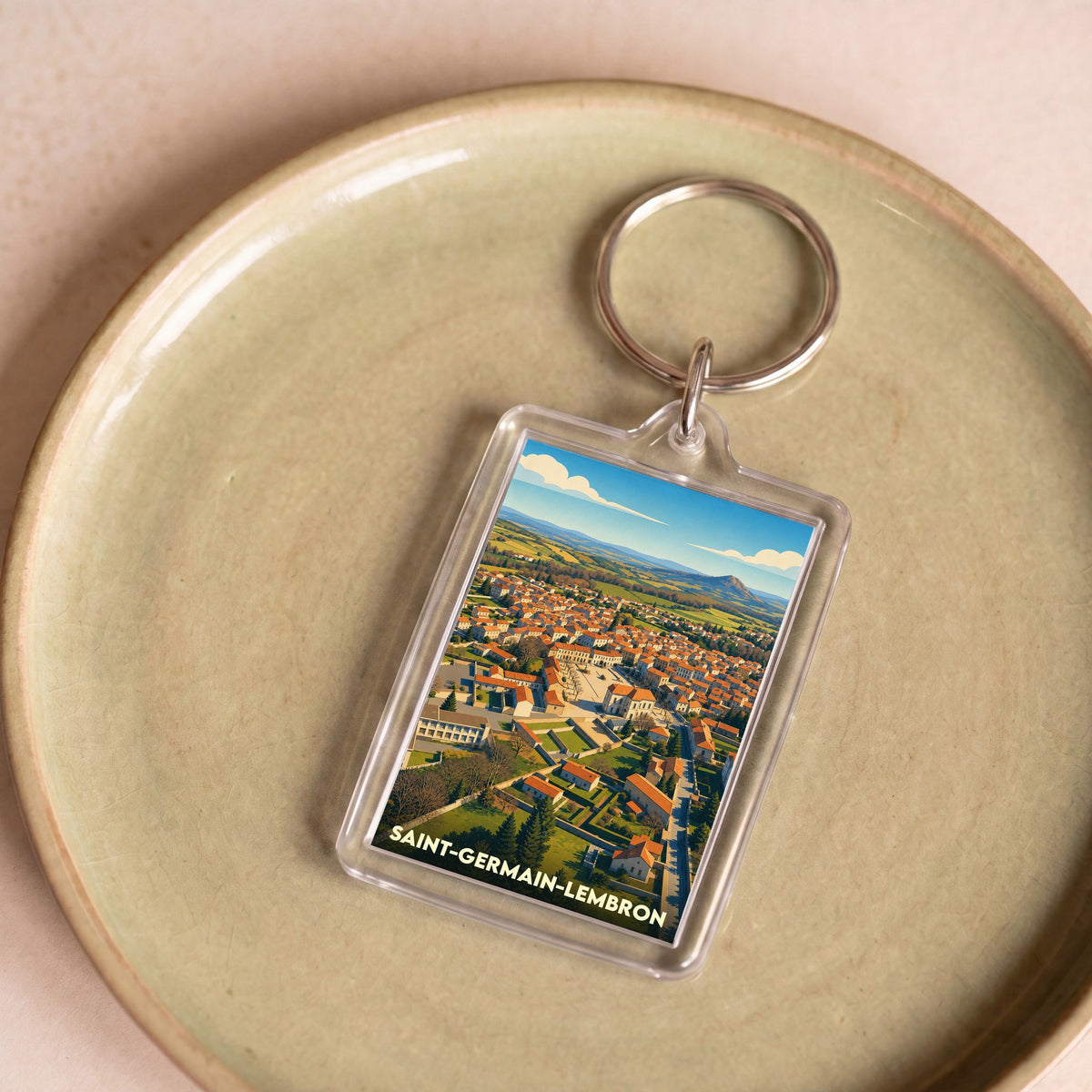 Porte-clés souvenir de la ville de Saint-Germain-Lembron avec une illustration stylisée.