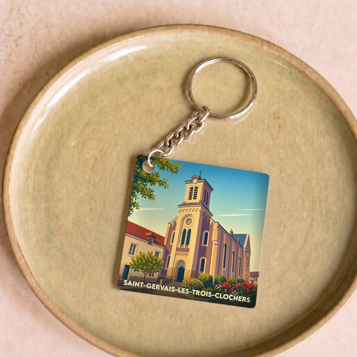 Porte-clés souvenir de la ville de Saint-Gervais-les-Trois-Clochers avec une illustration stylisée de son église.
