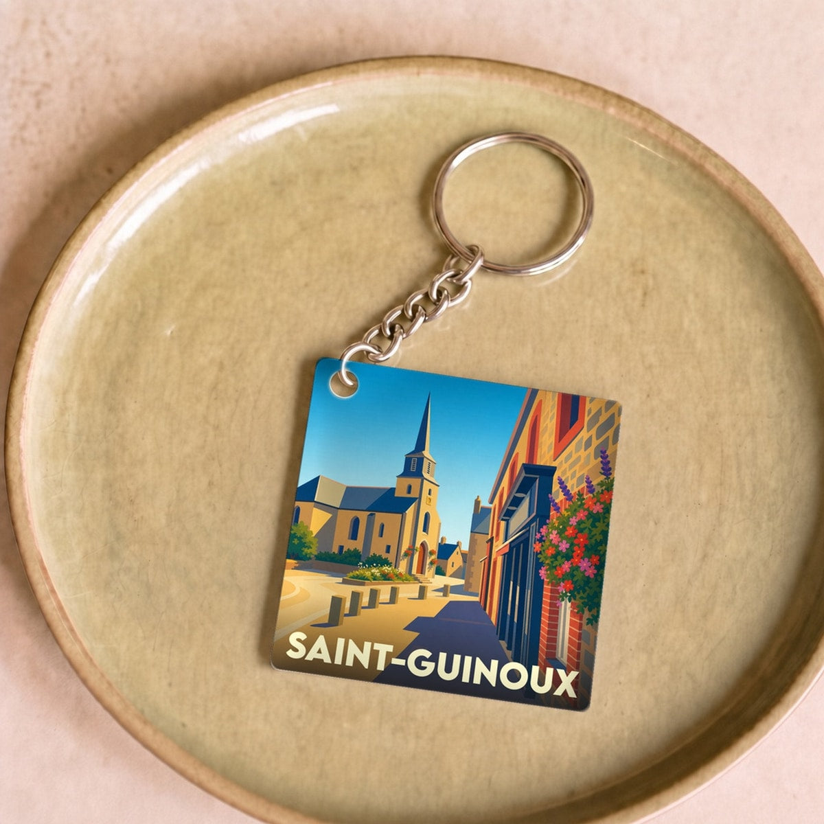 Porte-clés souvenir de la ville de Saint-Guinoux avec une illustration stylisée.