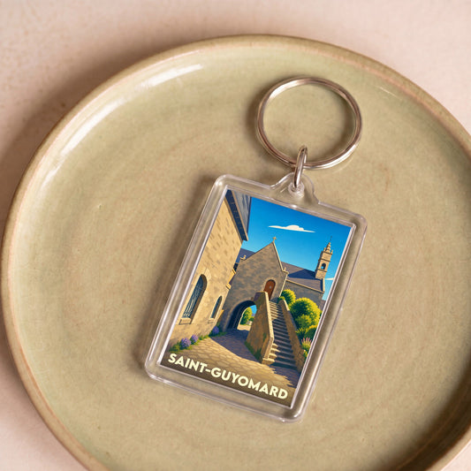 Porte-clés souvenir de la ville de Saint-Guyomard avec une illustration stylisée d'un bâtiment historique.