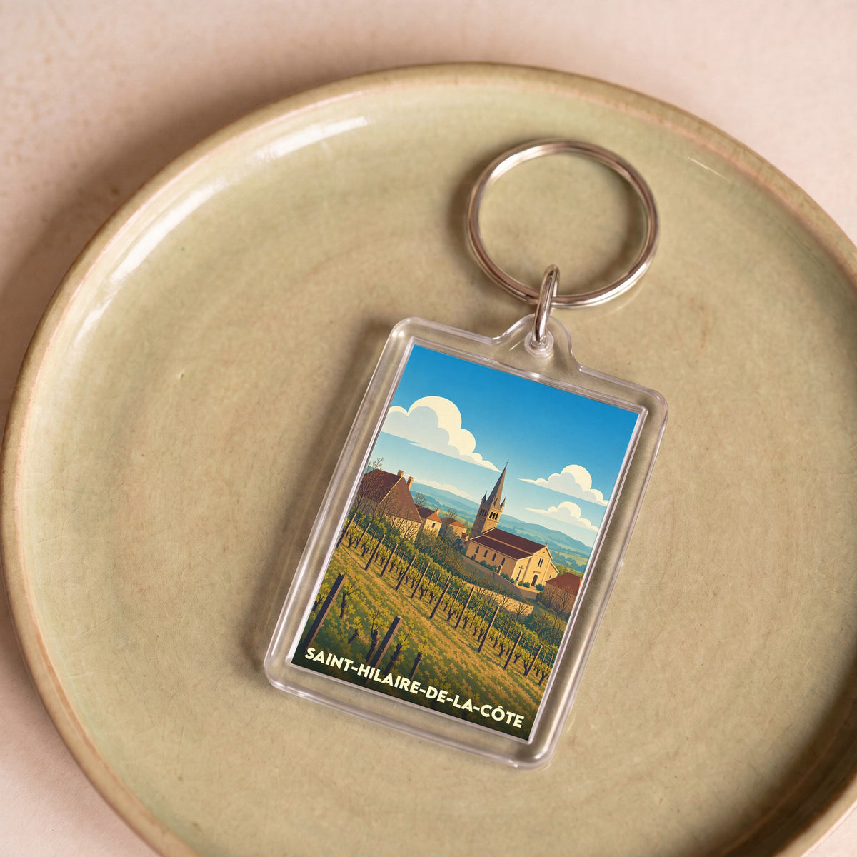 Porte-clés souvenir de la ville de Saint-Hilaire-de-la-Côte avec une illustration stylisée.