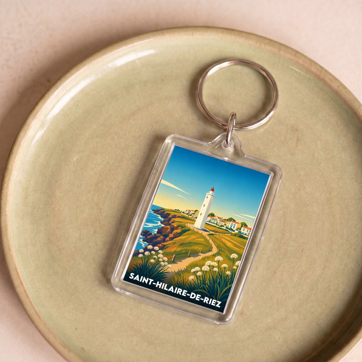 Porte-clés souvenir de la ville de Saint-Hilaire-de-Riez avec une illustration stylisée d'un paysage côtier.