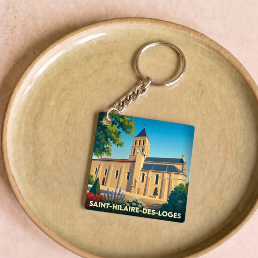 Porte-clés souvenir de la ville de Saint-Hilaire-des-Loges avec une illustration stylisée de son église.
