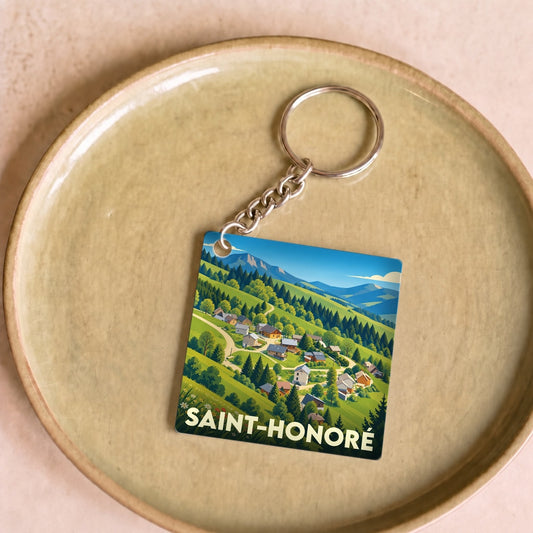 Porte-clés souvenir de la ville de Saint-Honoré avec une illustration stylisée de son paysage montagneux.